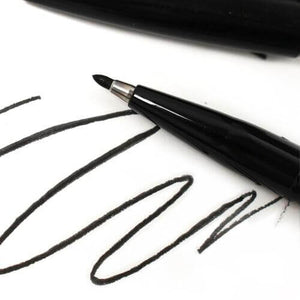 Pentel black sign pen writing black ink strokes on white paper
