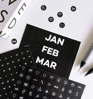 Black sticker sheets showing months, numbers, and white icon activity markers