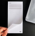 HELLO TIME Top 3 To-Do List Pad with hand turning page and mesh zip pouch on black surface
