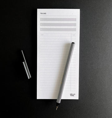 HELLO TIME Top 3 To-Do List Pad with black and white striped pen on black background