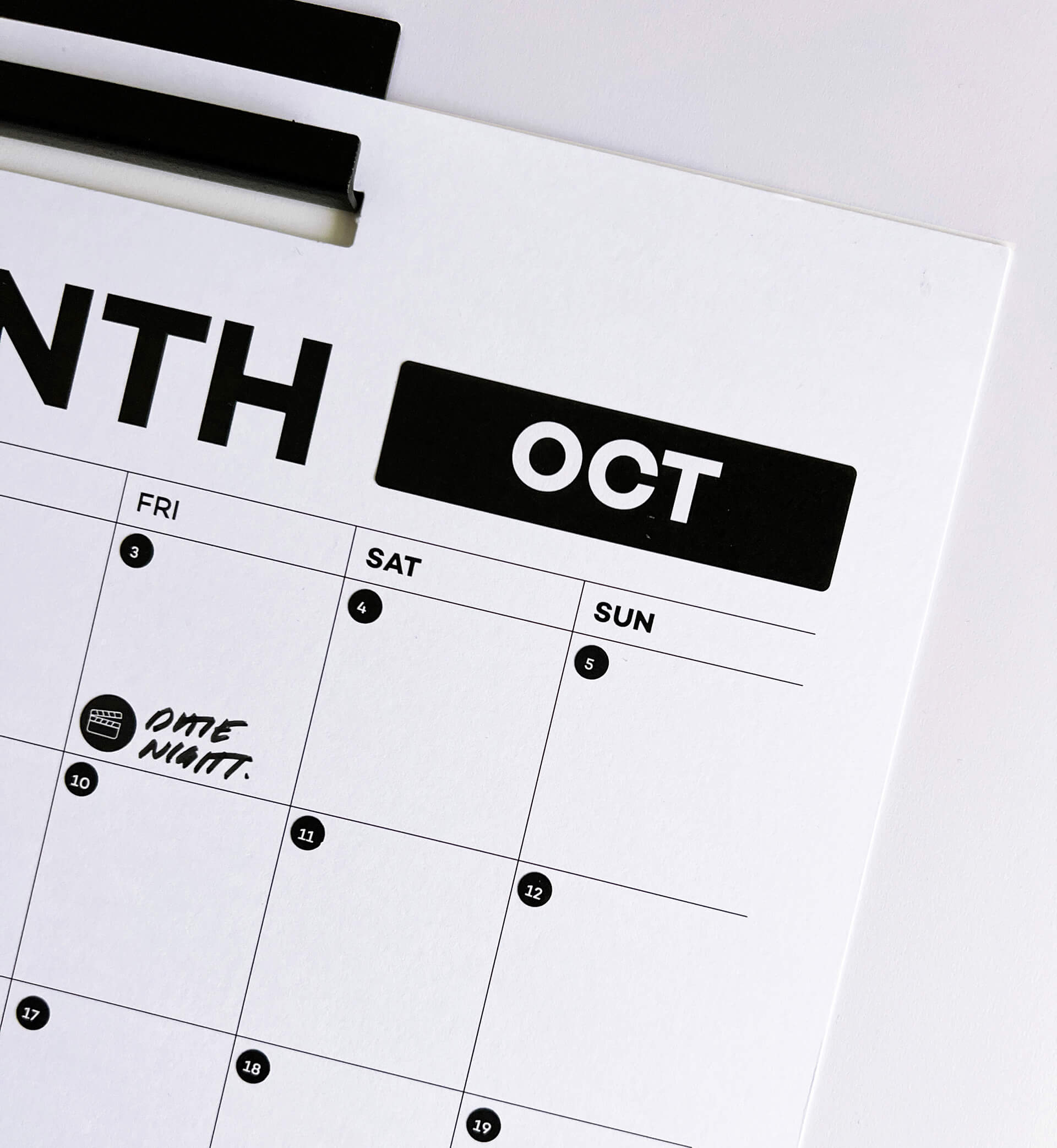 Close-up of wall planner showing October month with date night icon sticker