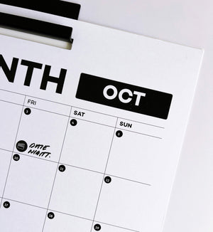 Close-up of wall planner showing October month with date night icon sticker