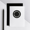 White greetings card with black circle design and Whoop Woo text, shown with black envelope.