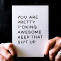 Person holding white birthday card with bold black text reading ‘You are pretty fcking awesome keep that sht up’.