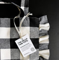Black and white check tote bag with ruffled edges and Hello Time label