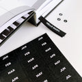 Black monthly stickers for Hello Time Diary with white text and open planner