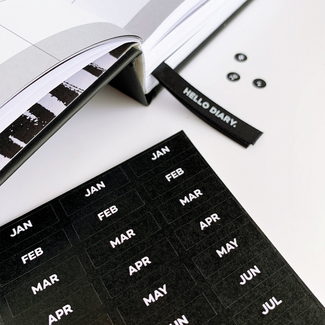 Black monthly stickers for Hello Time Diary with white text and open planner