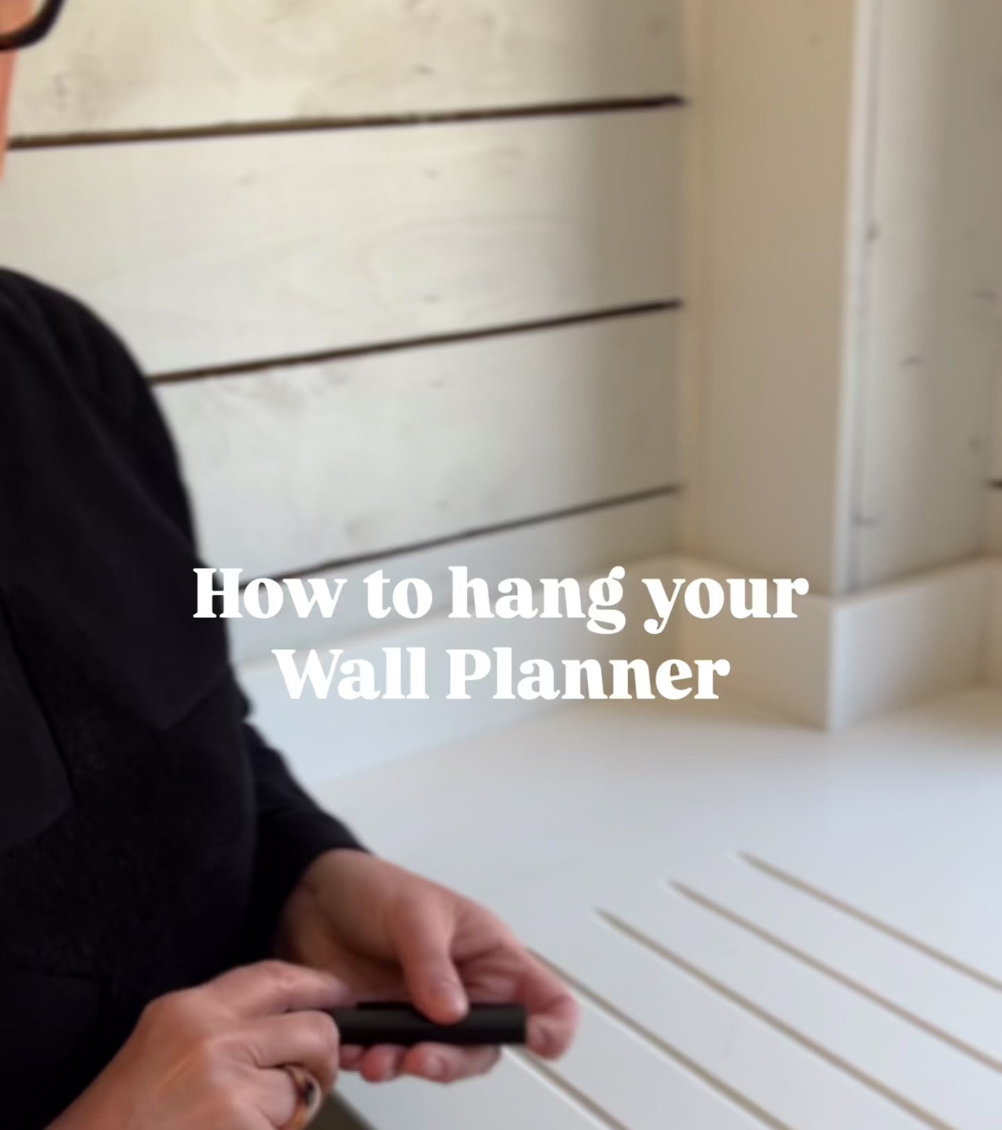 Lady showing you how to fix and hang your HELLO TIME Wall Planner.